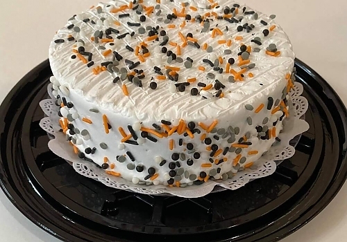 A cake with a blue and white frosting on it showcasing mango tres leches.